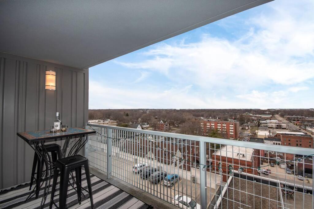 a balcony with a table and a view of a city at Luxury Condo in Downtown Champaign in Champaign