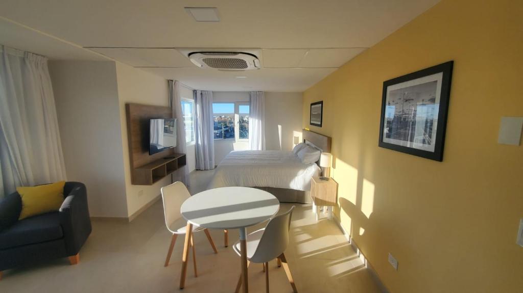 a small room with a bed and a table and chairs at CQ PARRY in Puerto Madryn