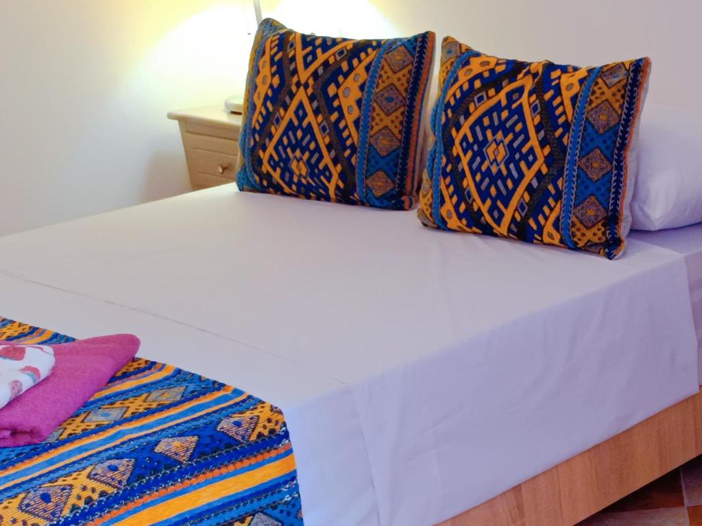Una cama con dos almohadas encima. en SULTANA Beach Riad en Saïdia