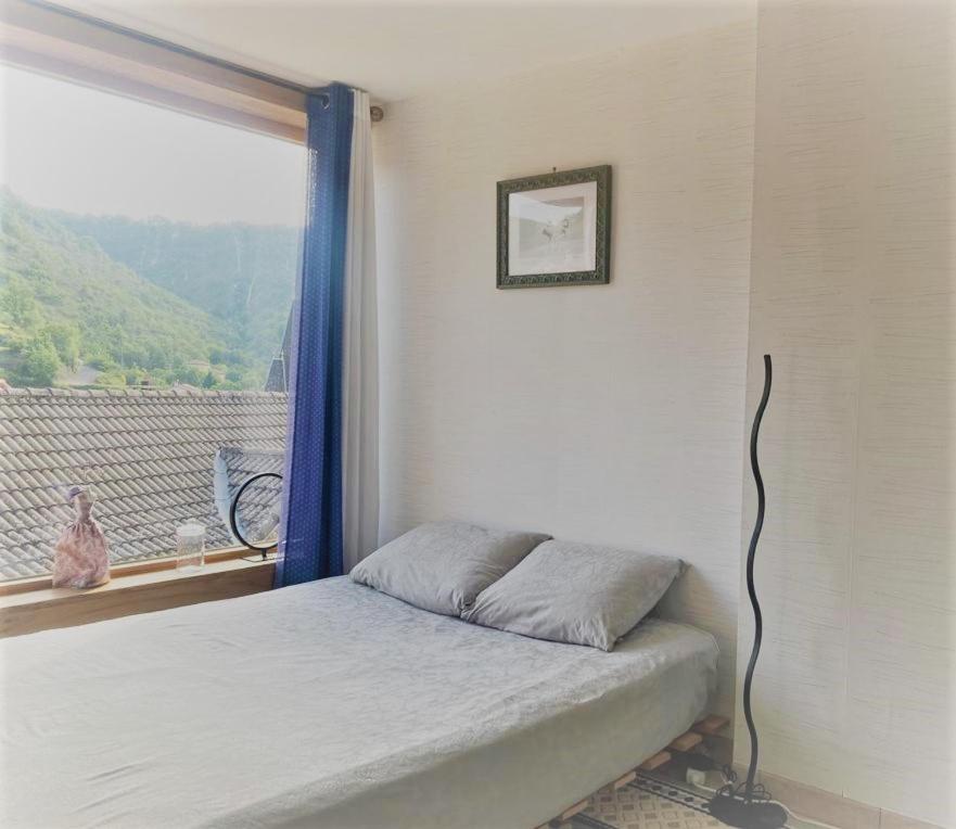 a bedroom with a bed and a window with a view at Le Cocon in Verrières