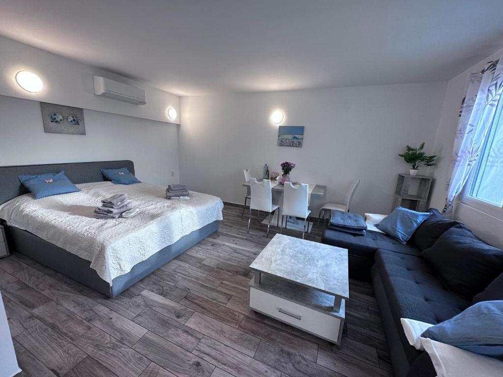 a living room with a bed and a couch at Sunny Apartments Podersdorf am See in Podersdorf am See