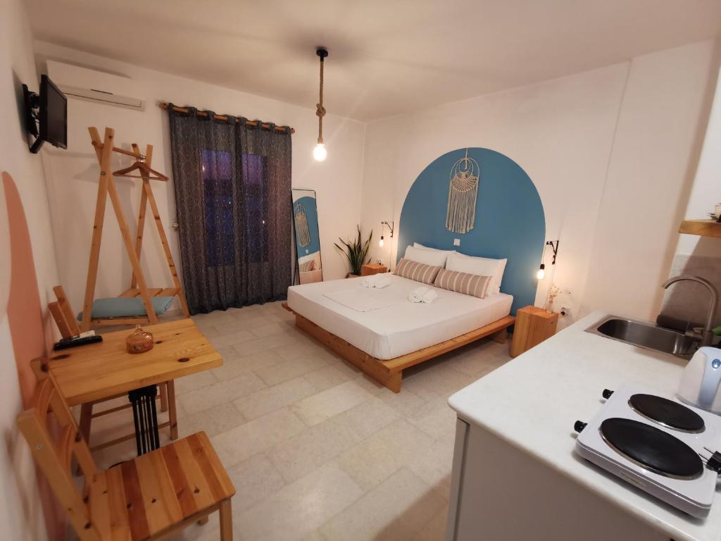 a bedroom with a bed and a kitchen with a table at KR Apartments in Aliki