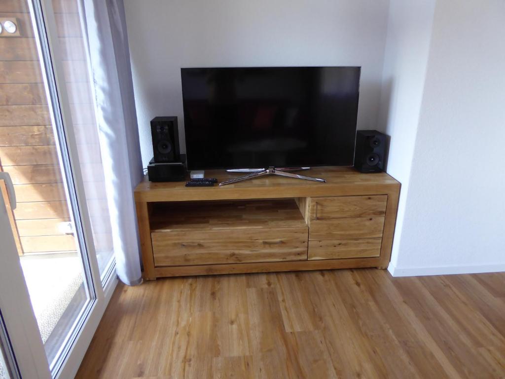 a flat screen tv sitting on top of a wooden dresser at Chalet Gerbera in Wengen
