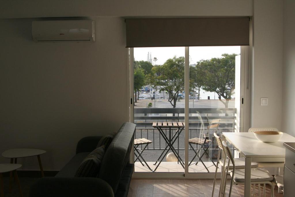 uma sala de estar com um sofá, uma mesa e uma varanda em Azul Cielo em Ayamonte