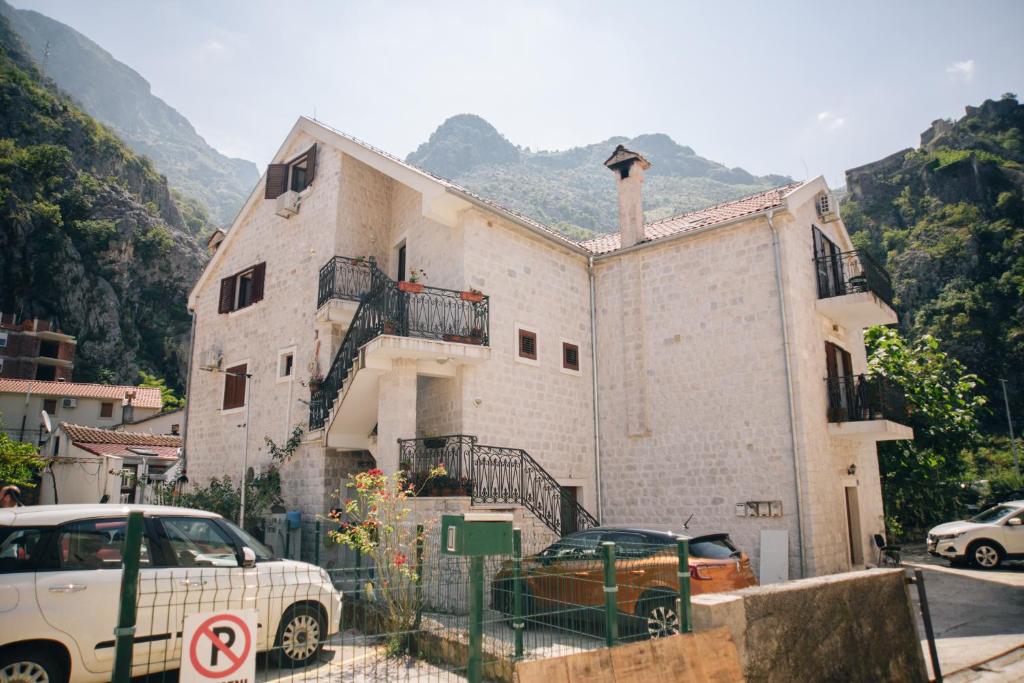 a building with cars parked in front of it at Filip Deluxe Rooms in Kotor