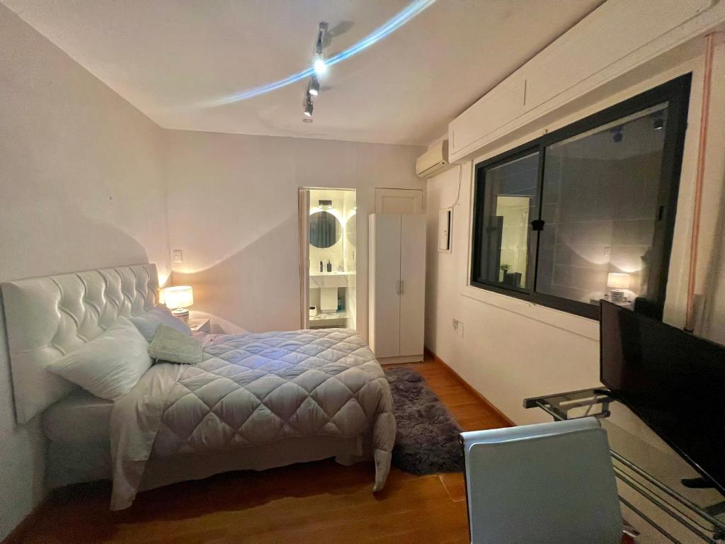 1 dormitorio con 1 cama y TV de pantalla plana en Habitacion en Carrasco, cerca del aeropuerto, en Montevideo