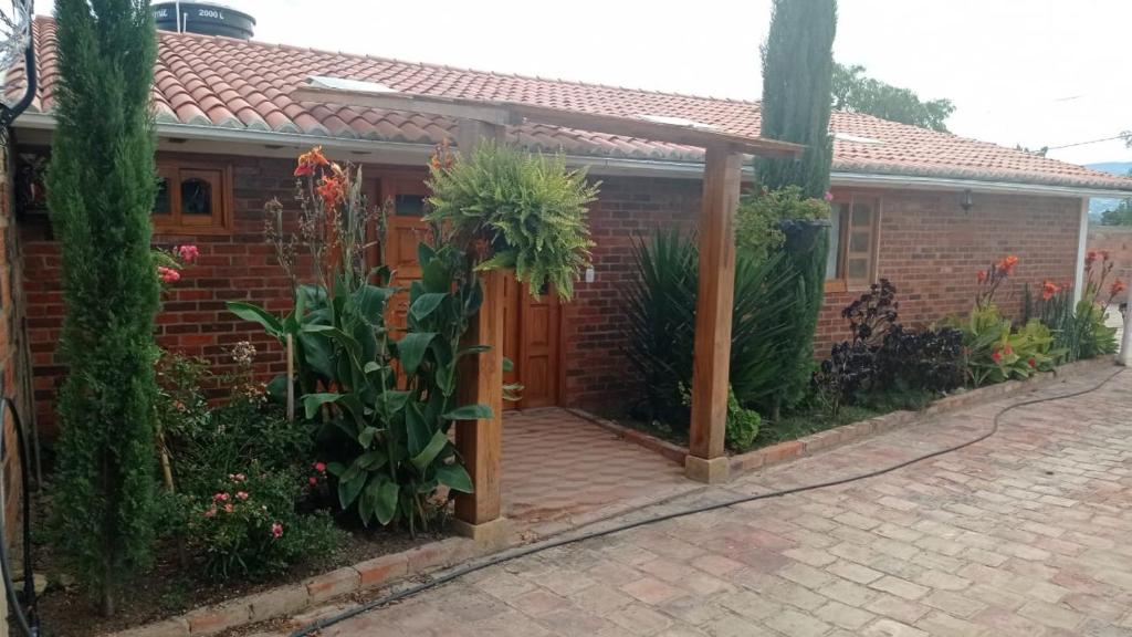 una casa de ladrillo con una puerta de madera y algunas plantas en Villa Almafe, en Villa de Leyva