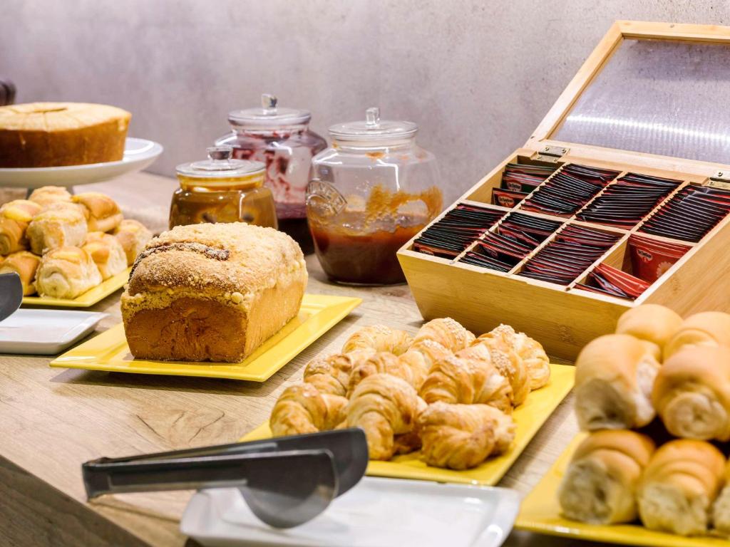 a table topped with different types of pastries and bread at ibis budget Porto Alegre - Supereconômico in Porto Alegre