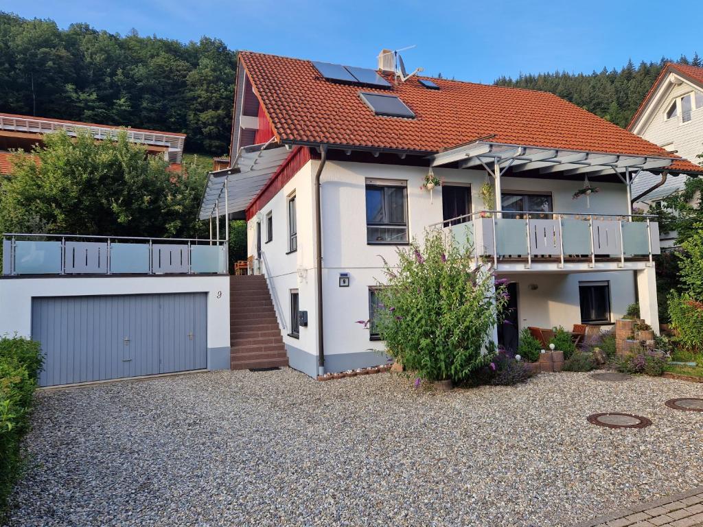 ein weißes Haus mit einem roten Dach und einer Auffahrt in der Unterkunft Schwarzwaldglück Apartment in Oberried