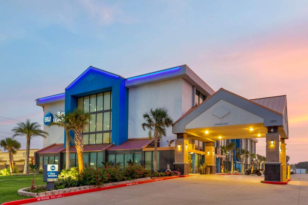 um edifício com palmeiras em frente em Best Western Corpus Christi Airport Hotel em Corpus Christi