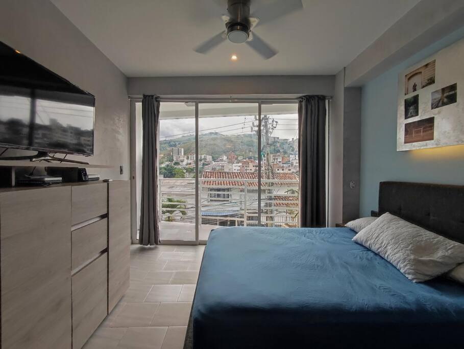 a bedroom with a bed and a large window at Design Studio Apartment with balcony and view in central and quiet area in Cali