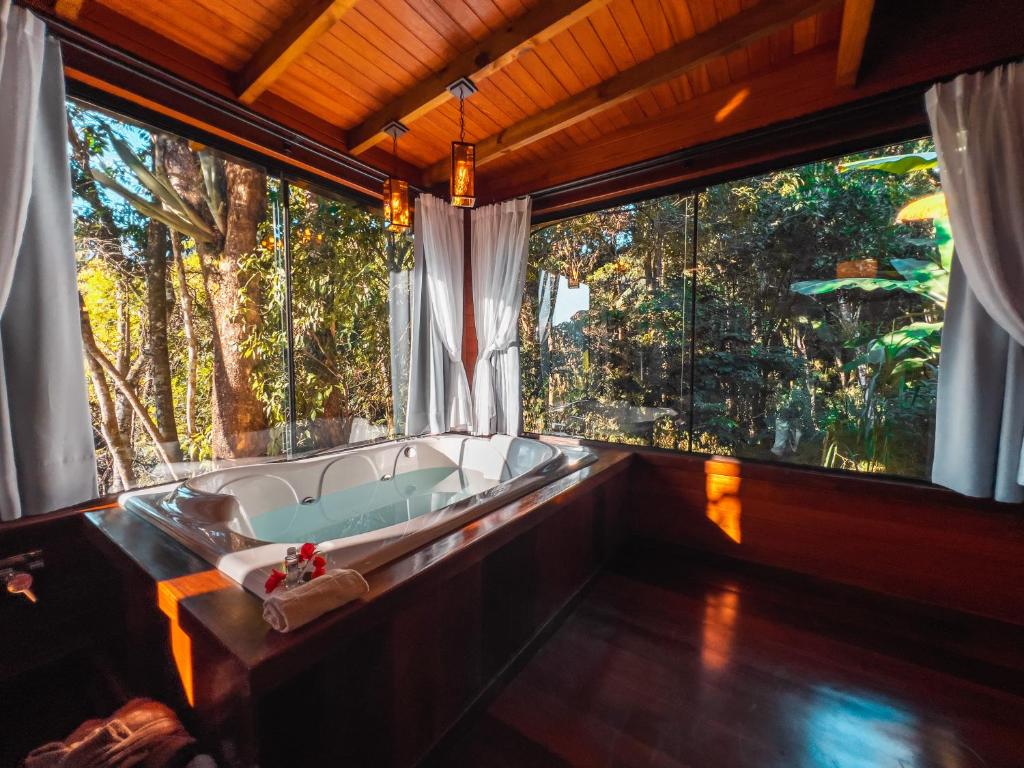 eine Badewanne in einem Zimmer mit einem großen Fenster in der Unterkunft Recanto Vera Lucia in Santo Amaro da Imperatriz