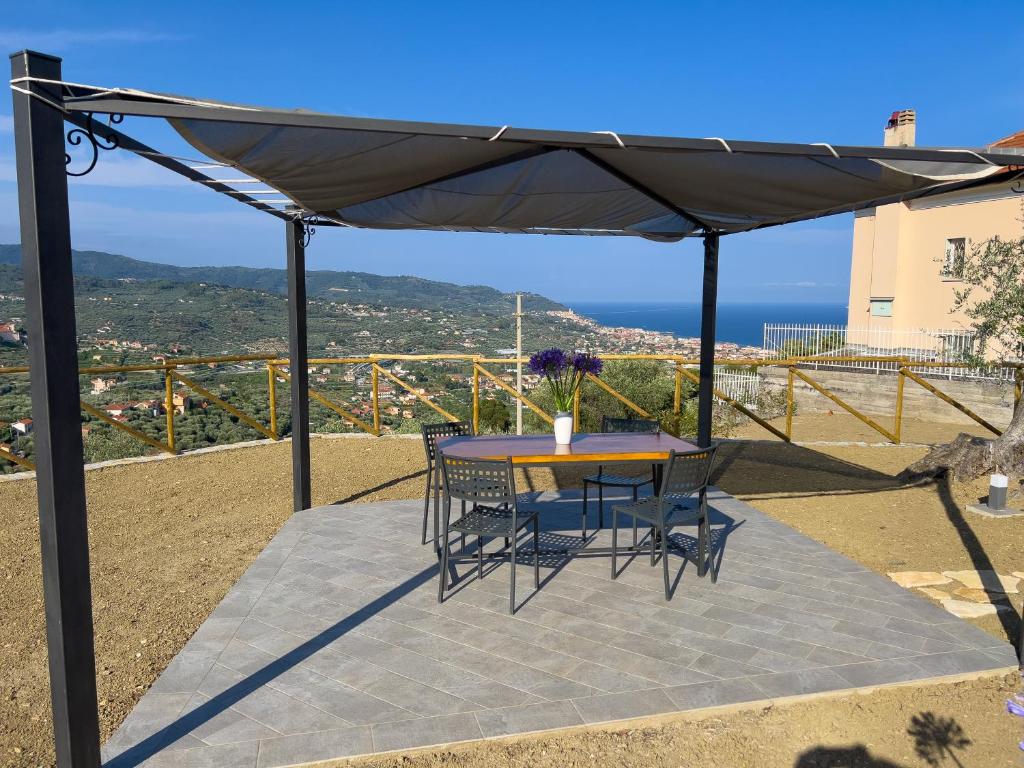 a patio with a table and chairs under a canopy at Casa Mara - Diano Serreta in Diano Marina