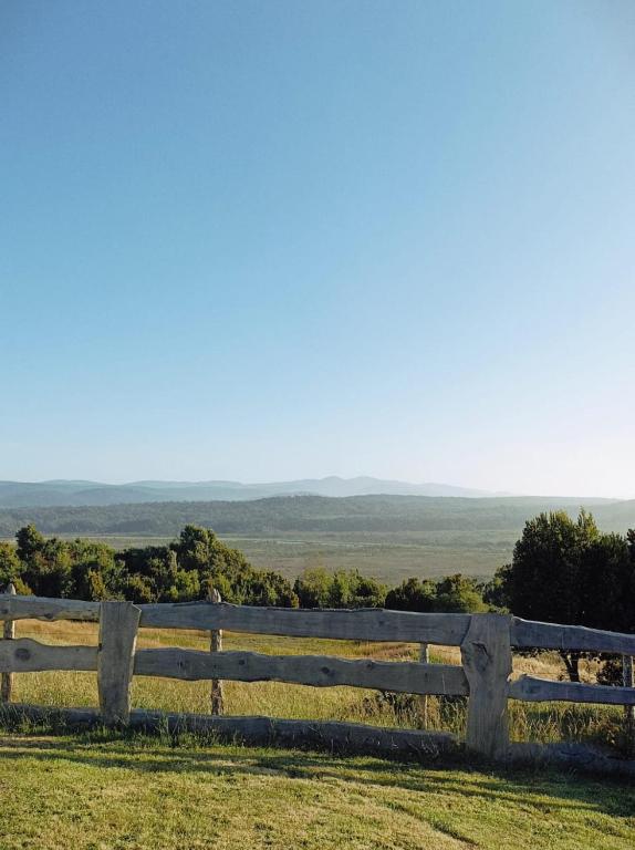 a fence on top of a field with a view at Cabañas Aulen Chepu Chiloe in Ancud