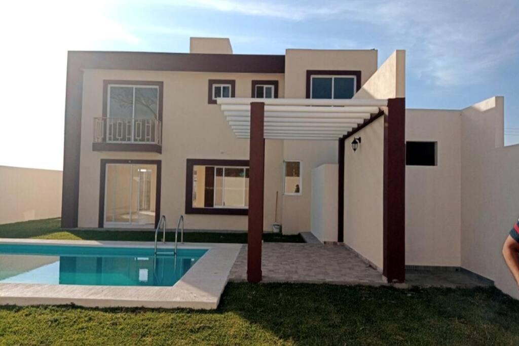 uma casa com uma piscina em frente em Alquiler de Hermosa Casa sola con Piscina Privada em Los Limones