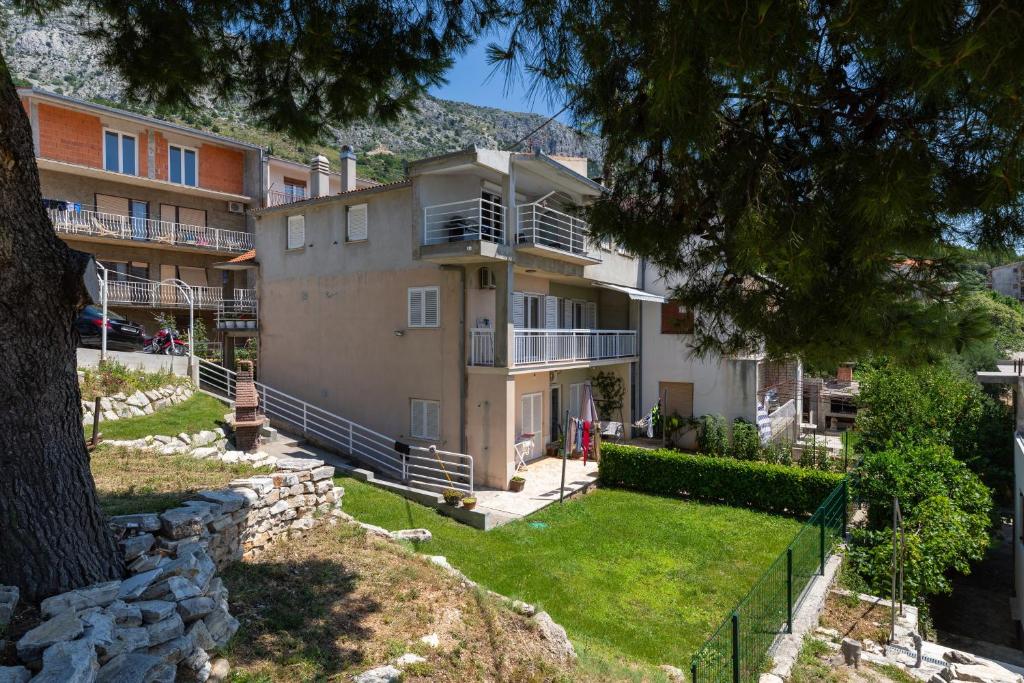 an apartment building with a yard in front of it at Apartments with parking space Stanici, Omis - 11421 in Celina