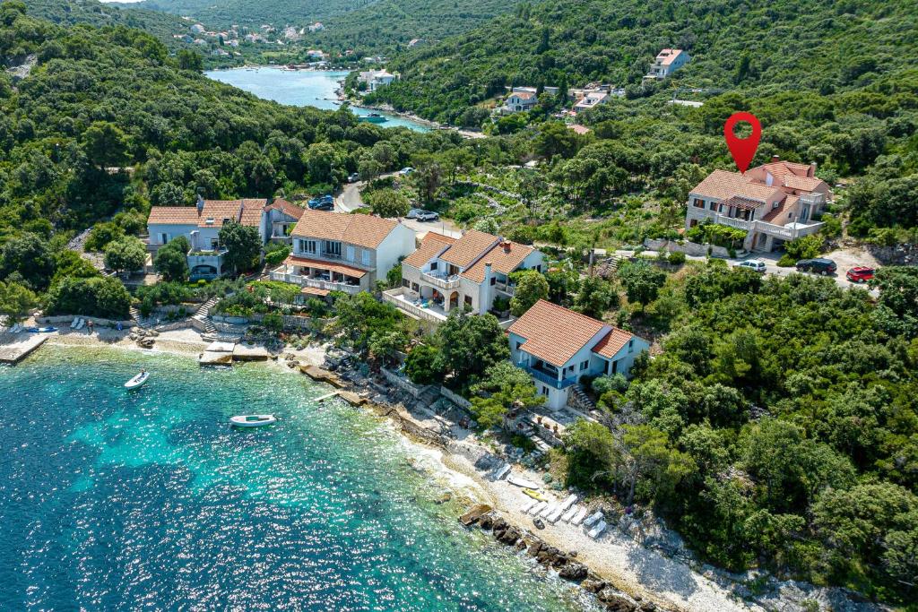 an aerial view of a house on a hill next to the water at Apartments by the sea Tri Zala, Korcula - 4432 in Korčula