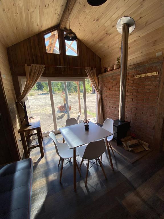 a dining room with a table and chairs and a fireplace at Hostal Dos Volcanes in Malalcahuello