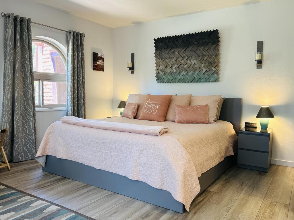 a bedroom with a large bed with pink pillows at Artsy Casita, King Bed, Walk to Trails & Food, Mountain Views, Trail Pass in Sedona