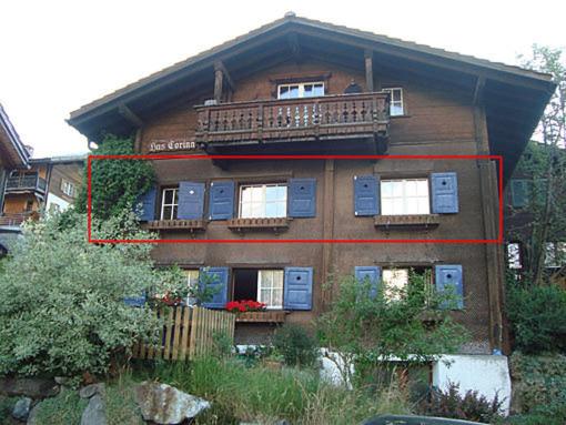 a large house with two windows and a balcony at Haus Corina in Klosters