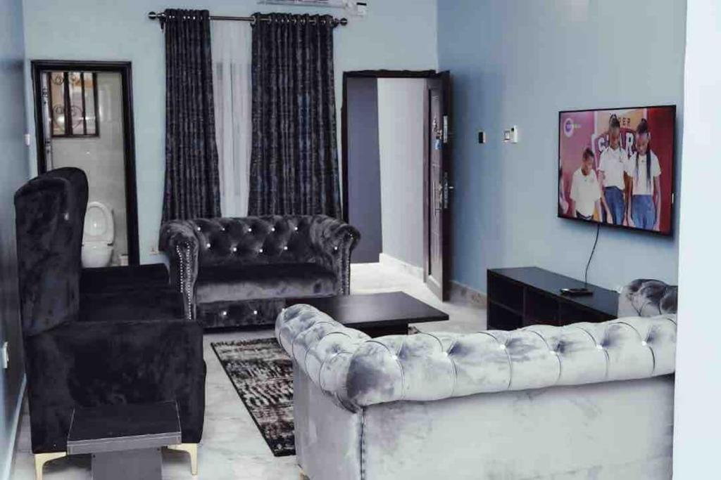 a living room with a couch and a chair at Cityflats Apartment in Owerri
