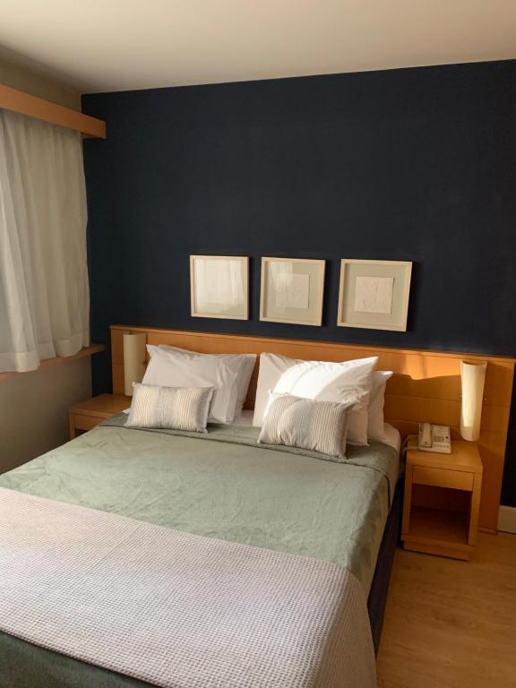 een slaapkamer met een groot bed met 2 kussens bij Hotel Boutique Jardins in Sao Paulo