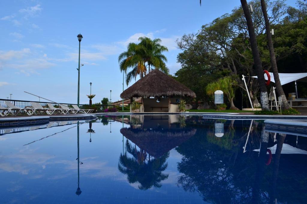 uma piscina com um gazebo e água azul em Real de Chapala em Ajijic