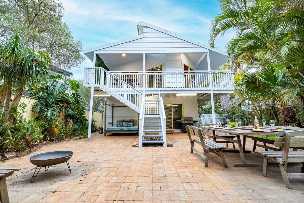 a house with a patio with a table and chairs at The Birubi Beach House 11 Campbell Ave Close to the beach pet friendly holiday home in Anna Bay