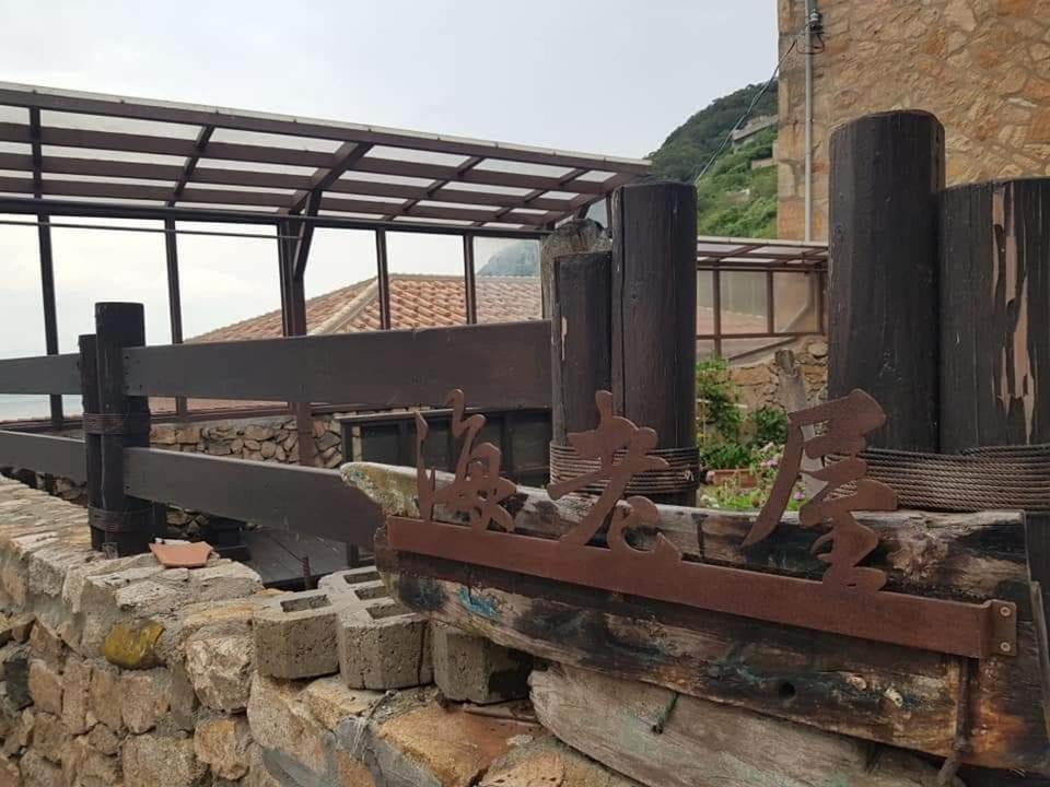 a rusty metal railing on top of a stone wall at Eternal Seaside House in Nangan