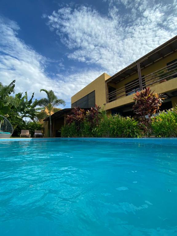 une grande piscine bleue en face d'un bâtiment dans l'établissement Bio Casa Inusual, à Girardot