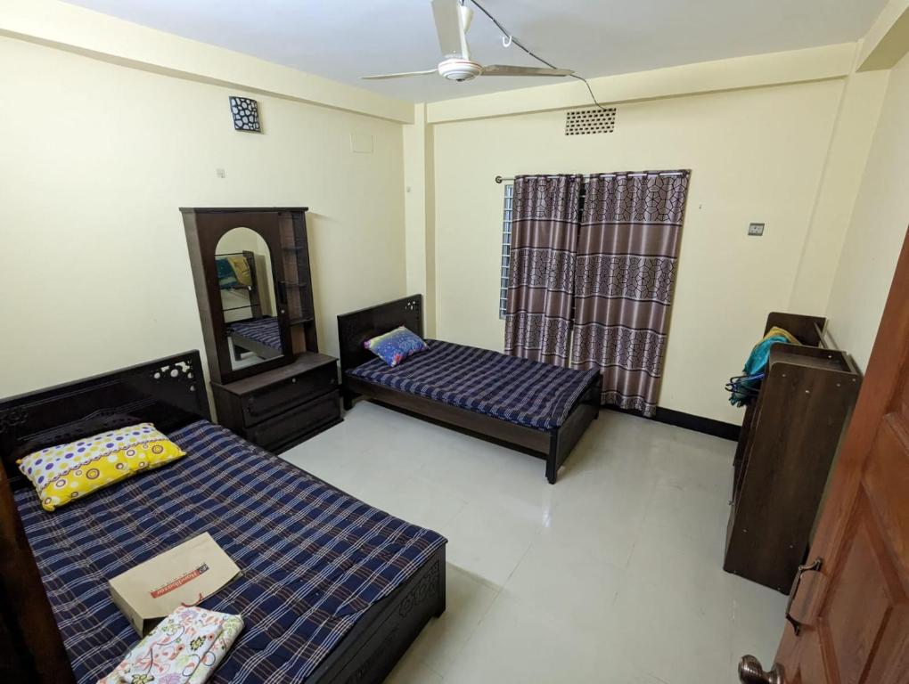 a room with two beds and a mirror at Rainagar rajbari in Sylhet