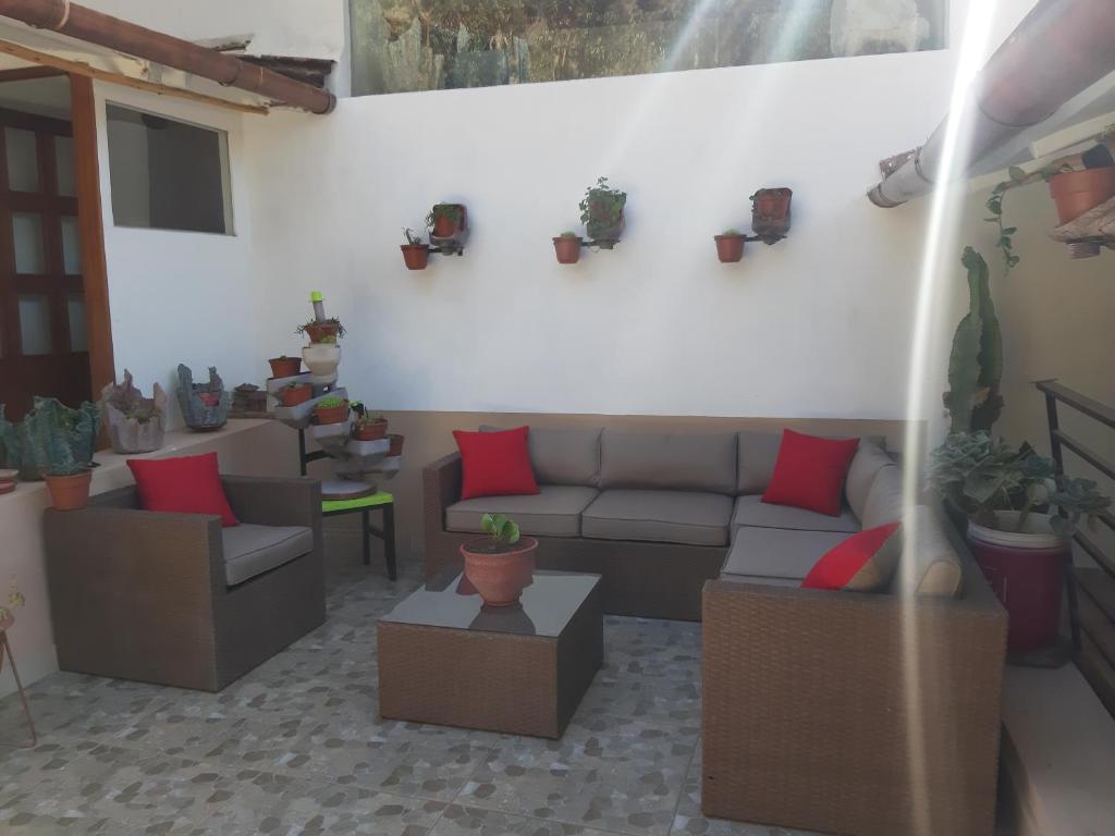 a living room with couches and plants on the wall at Casa Turística Las Tunas - Habitación: Apu Marcahuiri in Sicuani