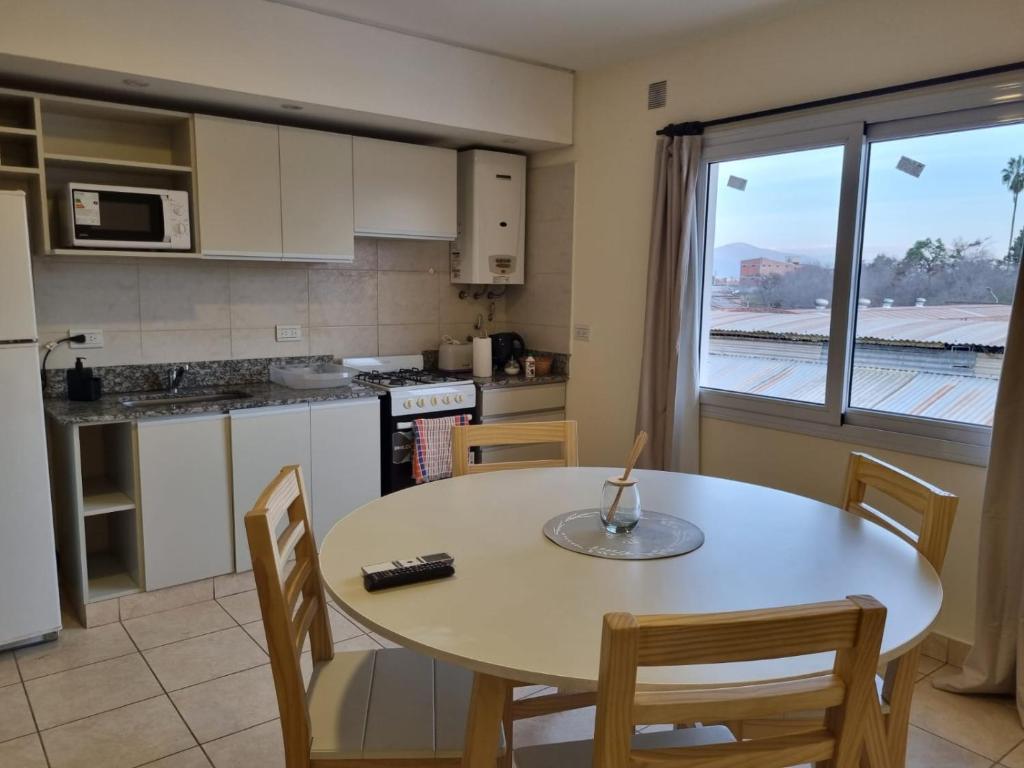 eine Küche mit einem Tisch und Stühlen sowie einem Fenster in der Unterkunft Confortable Departamento Salta in Salta