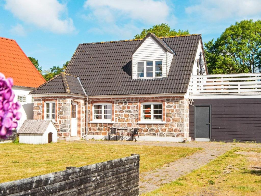 uma casa de pedra com um telhado preto em Holiday home Ebeltoft CCXXII em Ebeltoft