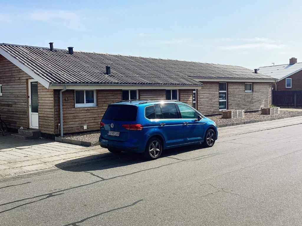 uma carrinha azul estacionada em frente a uma casa em Holiday home Thyborøn VI em Thyborøn