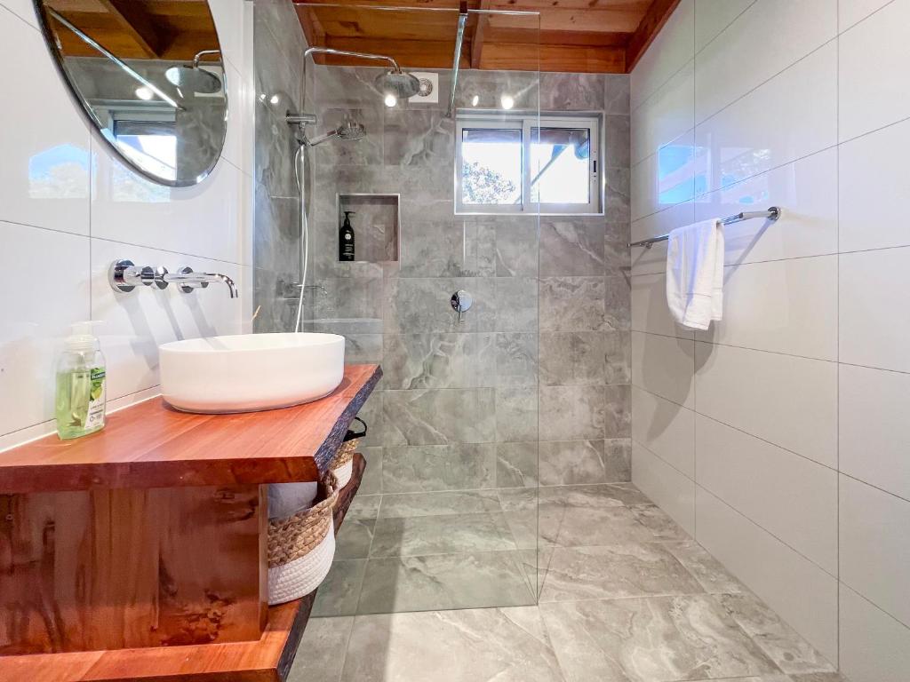 een badkamer met een wastafel en een douche bij HEXAGON BEACH HOUSE Binalong Bay of Fires Views in Binalong Bay