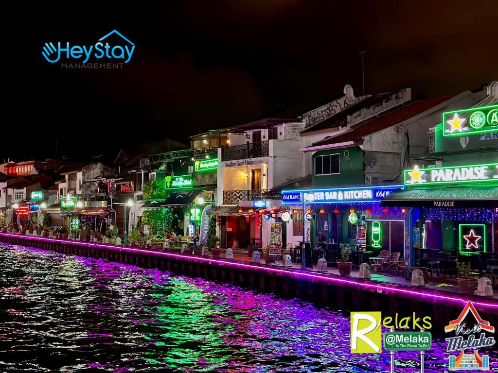 Eine Stadt leuchtete nachts neben einem Fluss in der Unterkunft Wayfarer Guest House Jonker Street Melaka By Heystay Management in Malakka