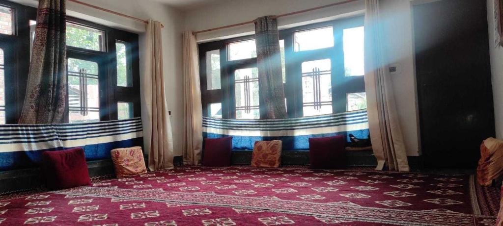 una stanza con due sedie e due finestre di POP Maryam Homestay a Gāndarbal