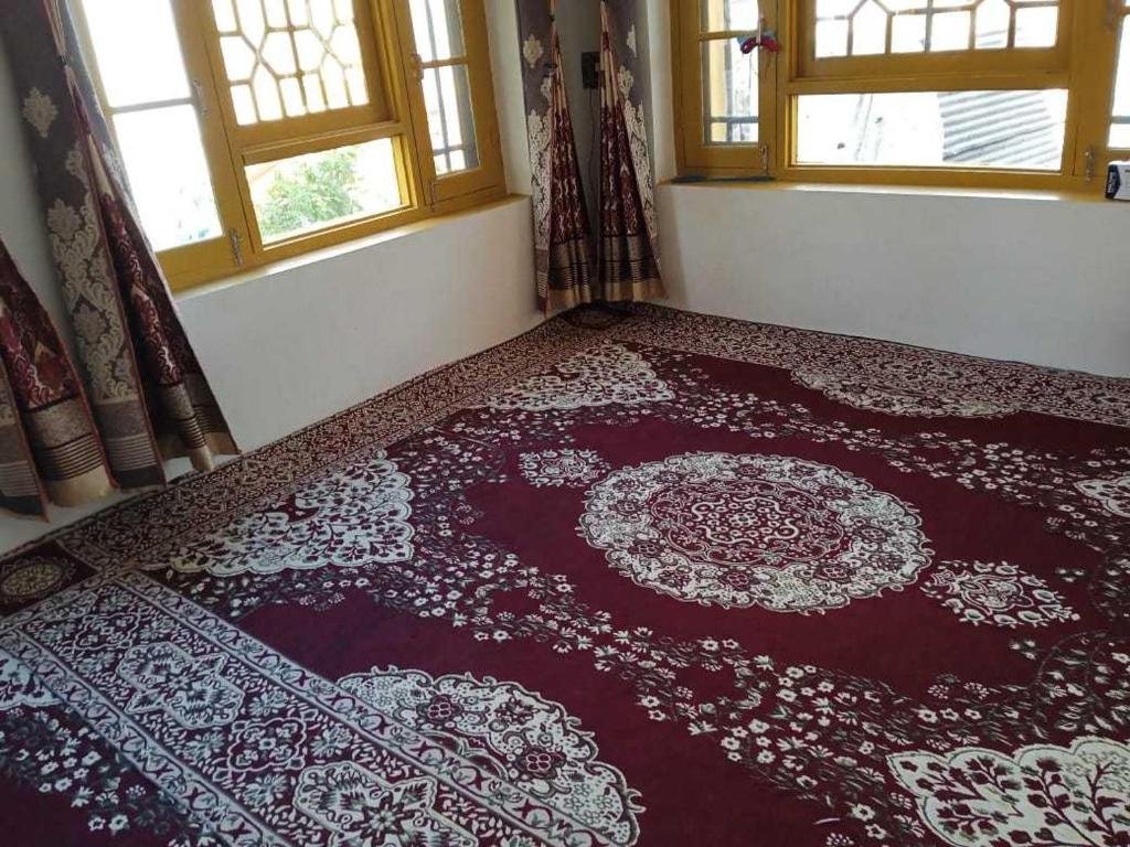 Habitación con alfombra roja en el suelo en OYO Home Shugufta Villa Homestay en Gāndarbal