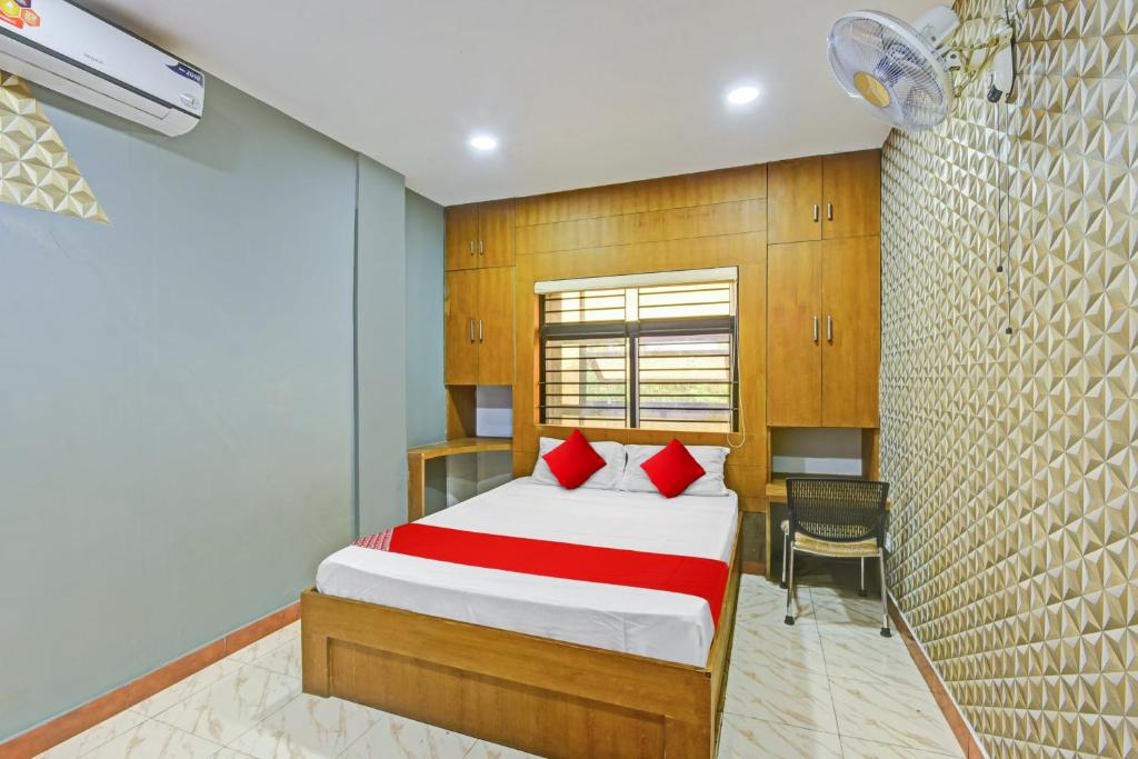a bedroom with a bed with red pillows and a desk at OYO Flagship Karipur Residency in Kondotti