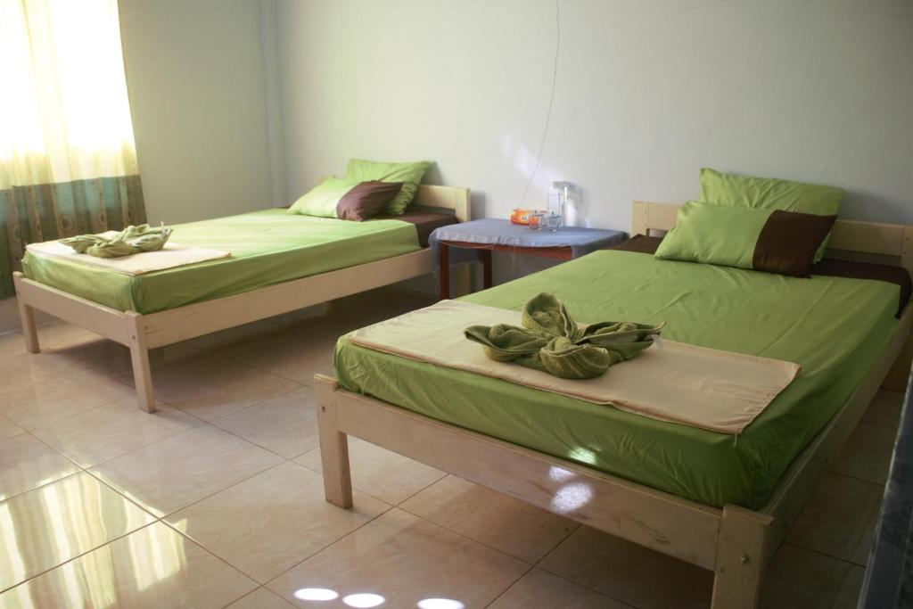 Zimmer mit 2 Betten und einem Sofa in der Unterkunft Tangkoko Gallery Guest House and Resto in Rinondoran