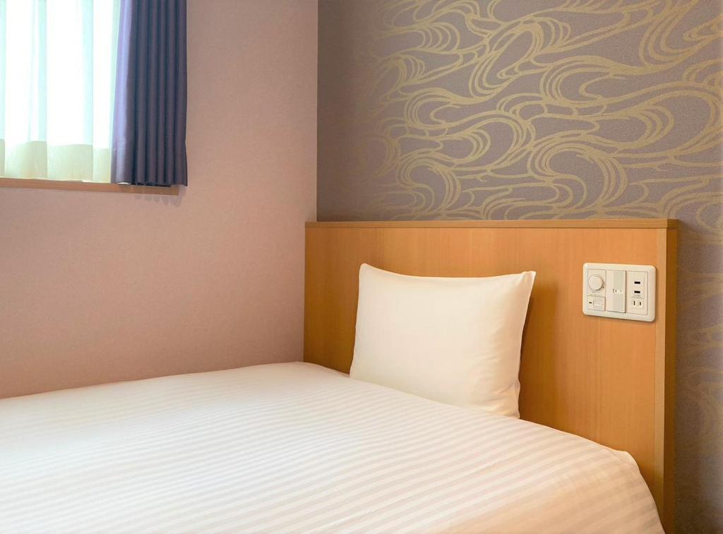 Postel nebo postele na pokoji v ubytování SAKURA SKY HOTEL KASHIWA(桜スカイホテル柏)