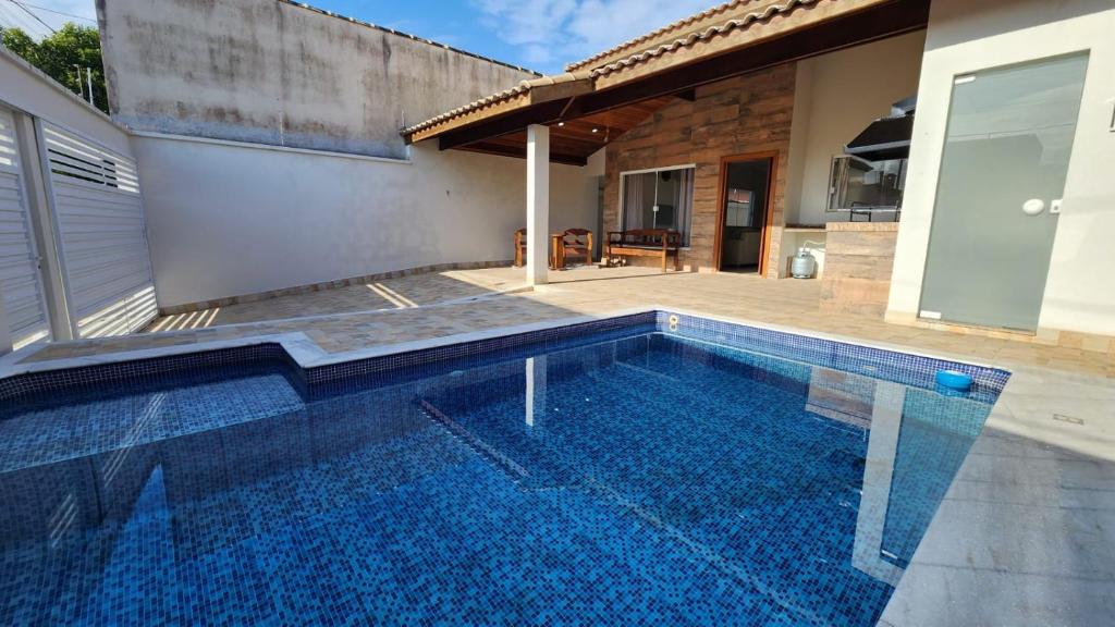 una piscina frente a una casa en Casa Peruibe com Piscina Mtk2, en Peruíbe