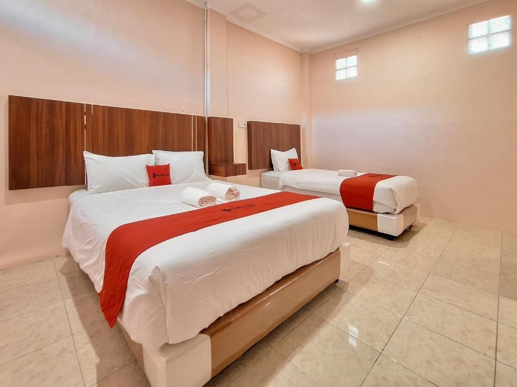 a bedroom with two beds in a room at RedDoorz Syariah near Pasar Raya Padang in Padang