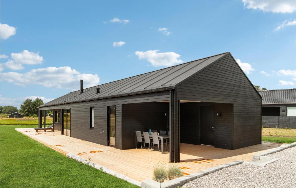 een huis met een zwart dak en een houten terras bij Gorgeous Home In Grenaa With Kitchen in Brøndstrup