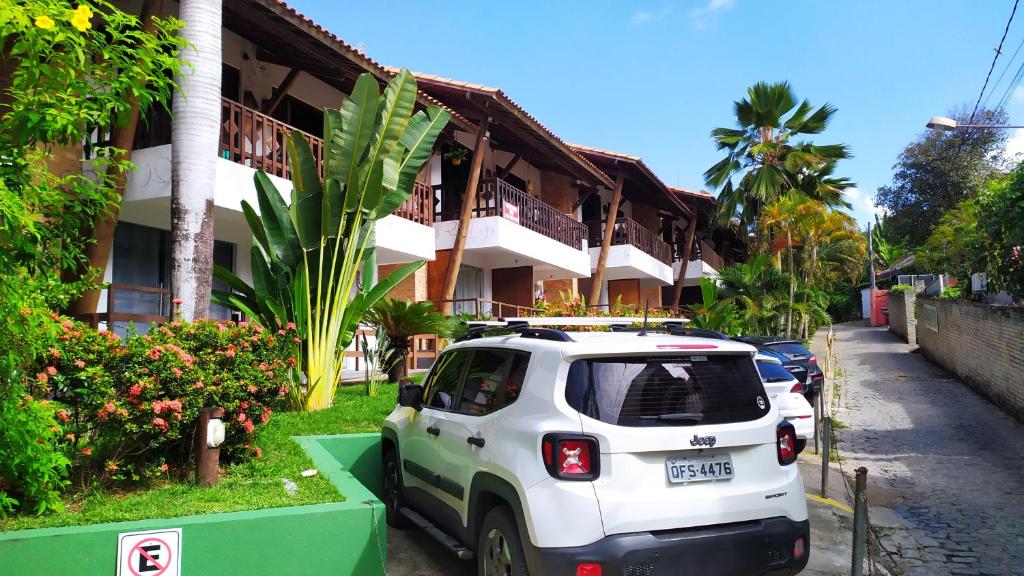 un coche blanco estacionado frente a un edificio en Apt no La Piazzetta-Centro de Pipa, en Pipa