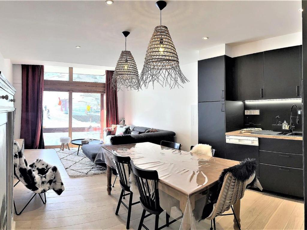 una cucina e un soggiorno con tavolo e sedie di Duplex spacieux au pied des pistes avec accès piscine - FR-1-267-255 a Villarembert