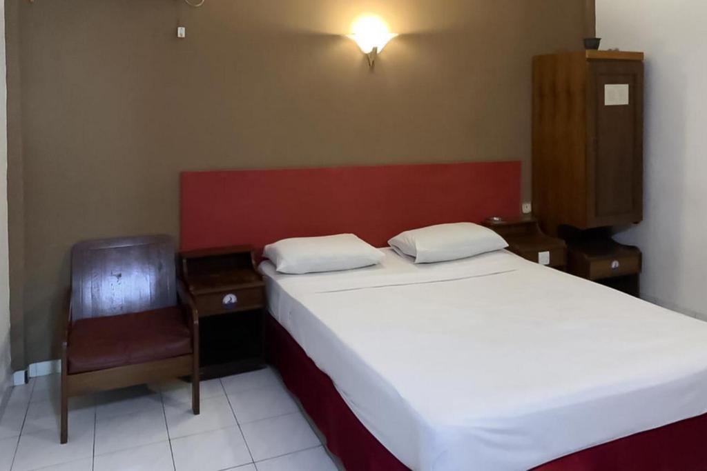 1 dormitorio pequeño con 1 cama y 1 silla en Hotel Laut Jaya Tanjung Pinang RedPartner en Tanjung Pinang