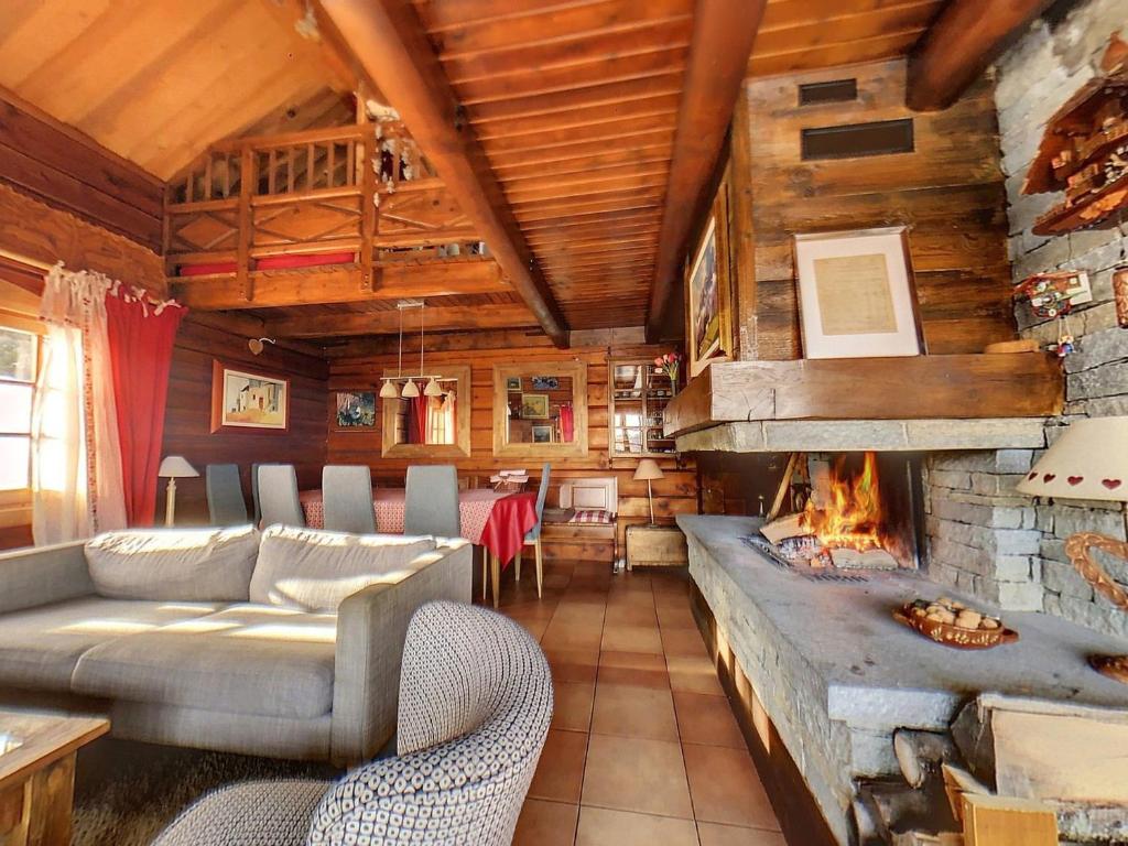 a living room with a couch and a fireplace at Chalet 4* tout confort au Corbier · Cheminée · Sauna · WiFi · Proche des pistes - FR-1-267-264 in Villarembert