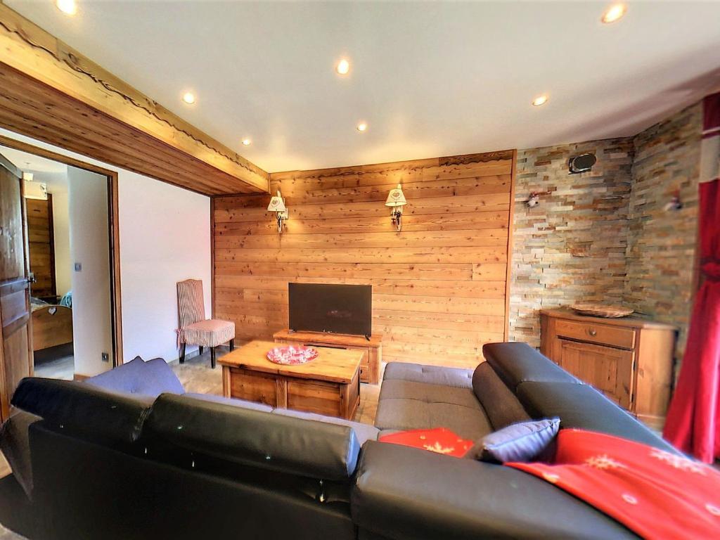 un soggiorno con un divano e una televisione di Chalet 3* · 8 pers · Grand confort · Terrasse · Parking privé - FR-1-267-266 a Villarembert